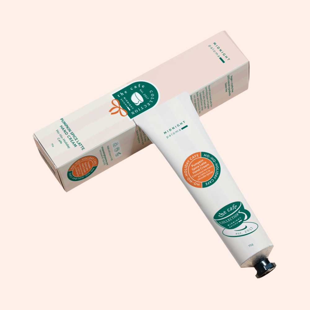 Hand cream tube and packaging with visible branding on a light pink background