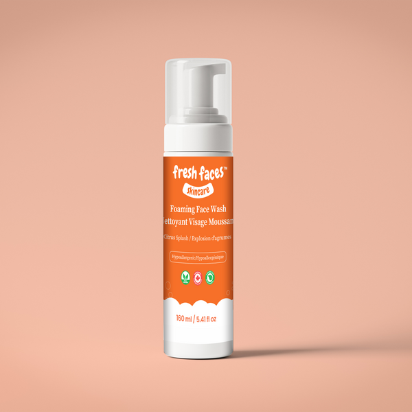 Foam face wash bottle with orange label on a peach background