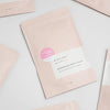 Pink packaging of handmade bath soap with a label on a light gray background