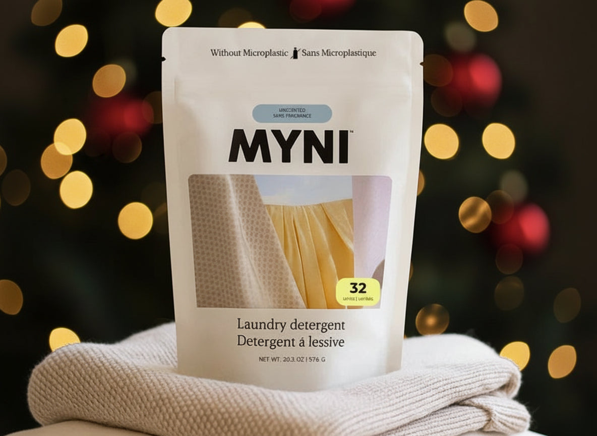 MYNI laundry detergent package on folded clothes with a blurred background